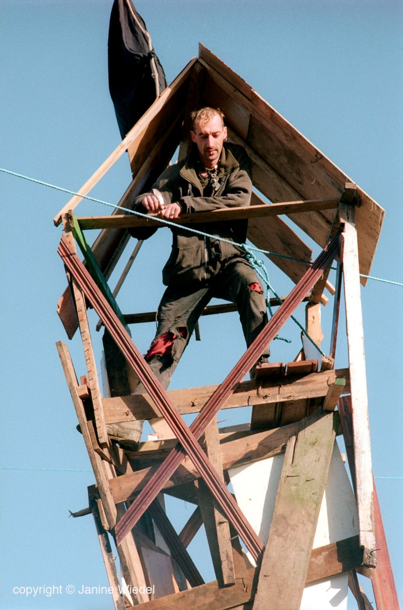 eco warrior climbing up into tower built as lookout defence while protesting at Crystal Palace park over proposed building of multi billion Pound leisure center on parkland.
